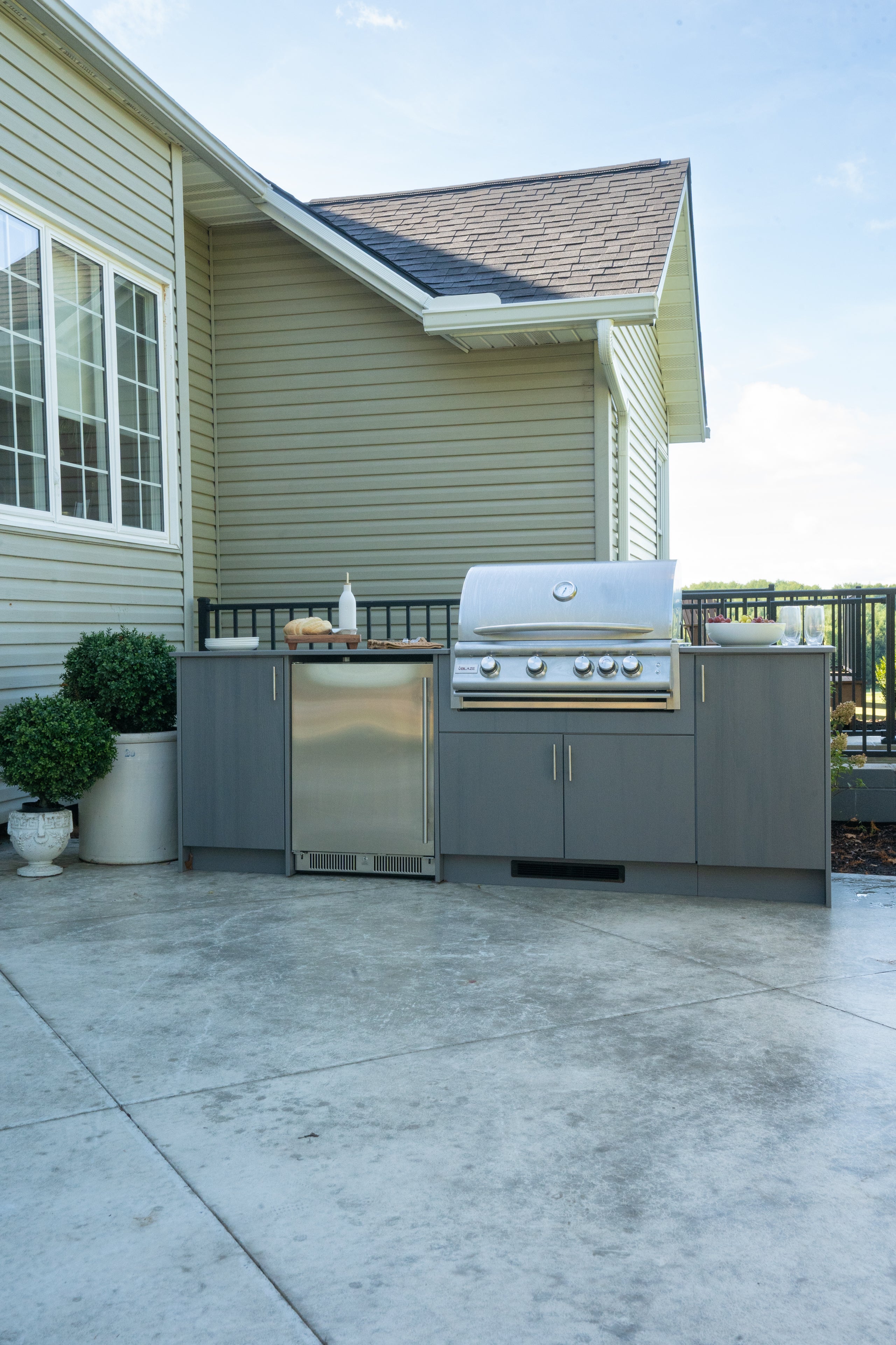 Compact outdoor kitchen with built-in grill, storage cabinets, and counter space on a small patio.
